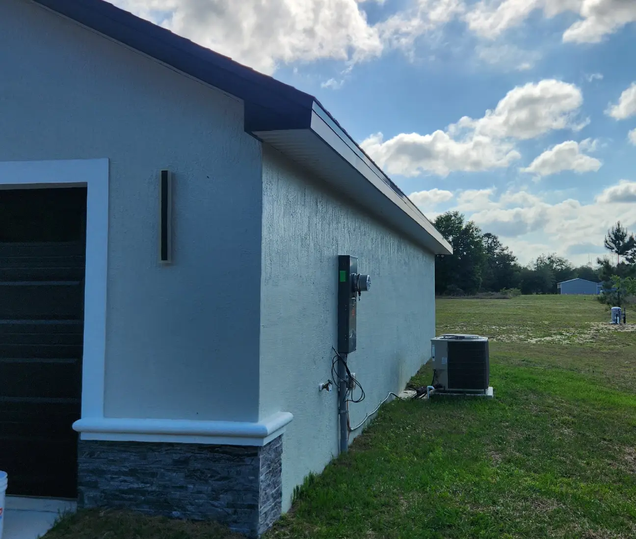 Dark gutter running along the roofline of a white stucco home