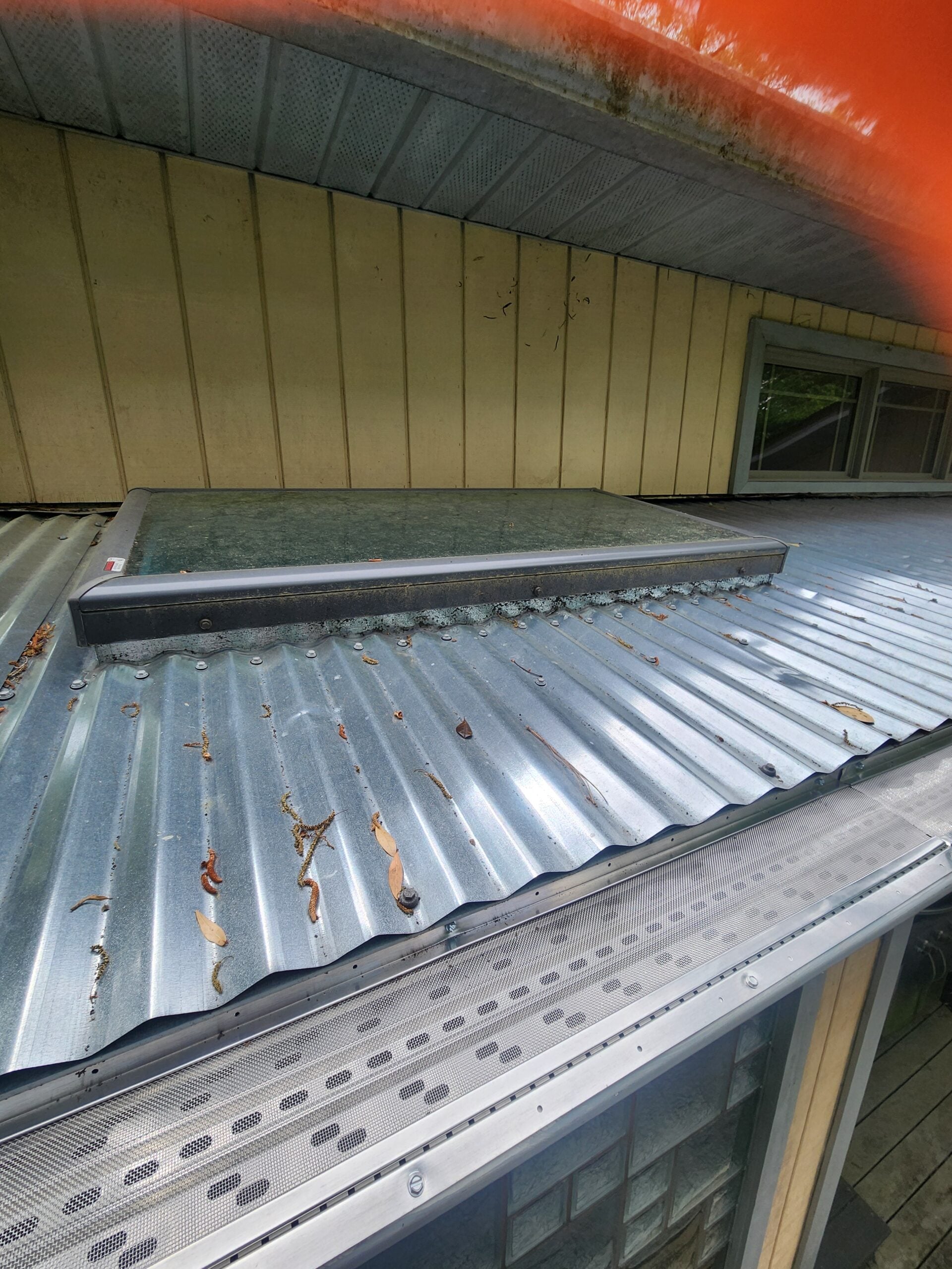 Aluminum awning box gutter retrofitted by Premium Leaf Guards so a leaf guard can shed debris instead of clogging
